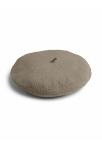 Berretto rotondo e piatto di colore beige, realizzato in morbido feltro, con una piccola linguetta superiore. Presenta una superficie liscia e un colore uniforme, senza motivi.