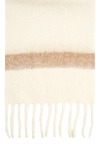 Couverture en mélange de laine crème avec une douce rayure brune. Présente des bords à franges et une texture lisse, idéale pour la chaleur et la décoration.