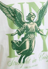Bijela pamučna majica s grafikom zelenog anđela s detaljnim krilima i letećim plaštem, uz zeleni natpis "UNIFY Snaga u jedinstvu."