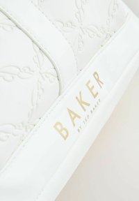 Sac en cuir blanc avec un motif floral embossé, arborant un logo doré "BAKER by TED BAKER" et une texture lisse.