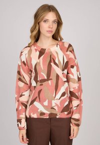 Pull en tricot avec un motif floral en rose, crème et brun. Encolure ronde, manches longues, et finitions côtelées au niveau des poignets et de l'ourlet. Texture douce.