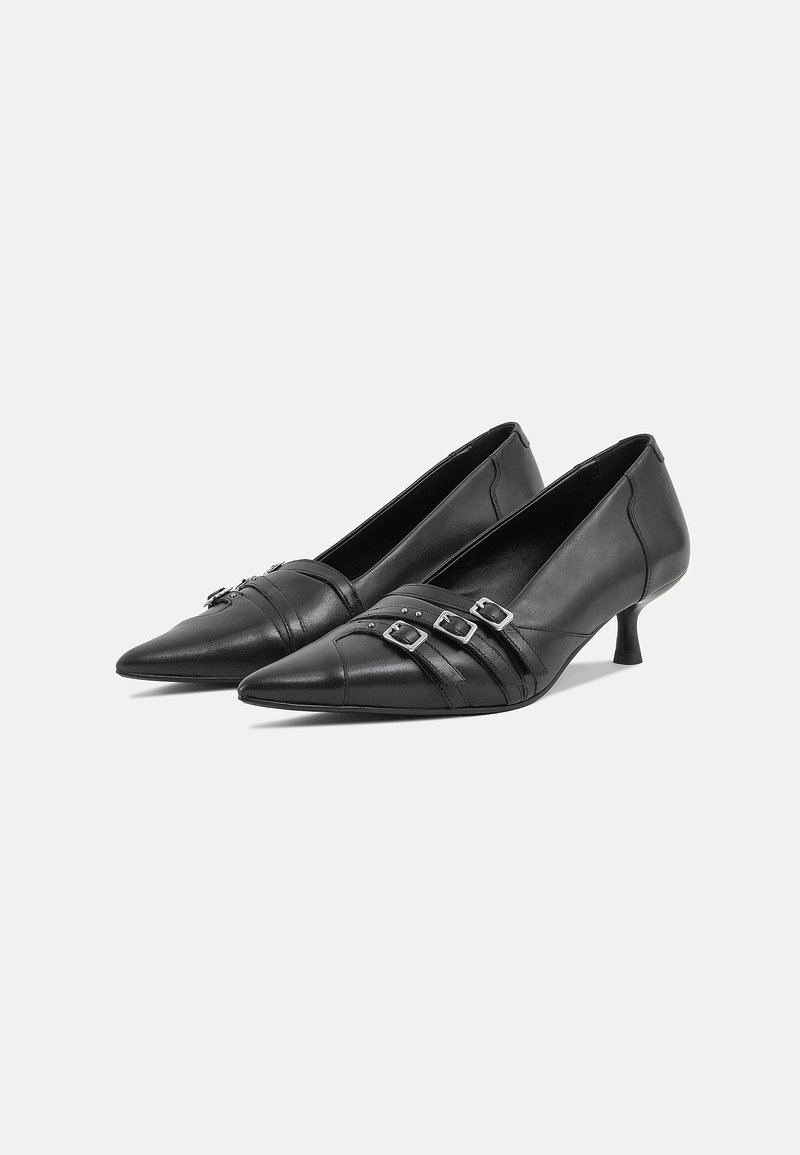 Zwarte leren hakschoenen met puntige neuzen, voorzien van een kruiselings bandontwerp en zilveren gespen. Lage hakken met een gladde, glanzende textuur.