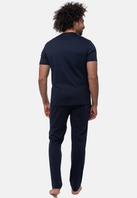 Marinblå bomullslounge-set, inklusive t-shirt med kort ärm och pyjamasbyxor, med en avslappnad passform och slät textur.