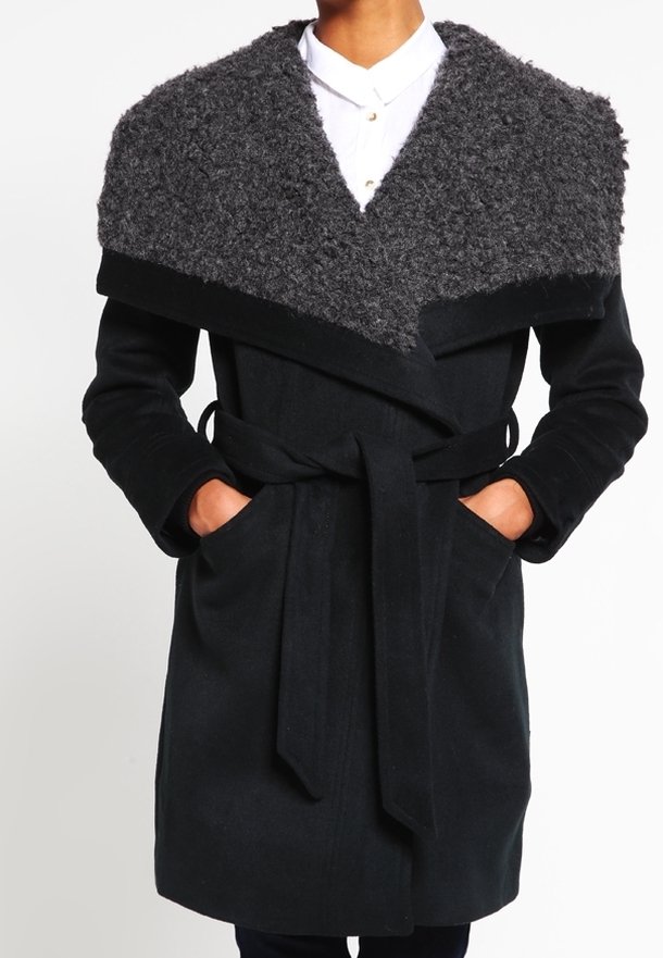 Cappotto di lana nero con colletto grigio peloso, design avvolgente, maniche lunghe, vita con cintura, tasche laterali e una consistenza morbida.