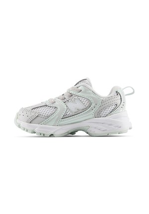 Sneaker da atletica bianca con pannelli in mesh grigio chiaro, suola spessa imbottita, lacci e linguetta sul tallone, mostrata di lato.