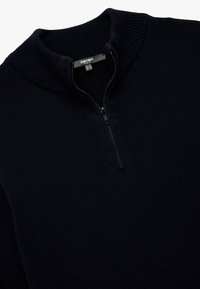 Suéter de cuello con cremallera en color azul marino, fabricado en un material de punto texturizado, que cuenta con un cuello acanalado y una cremallera de metal con un tirador negro.