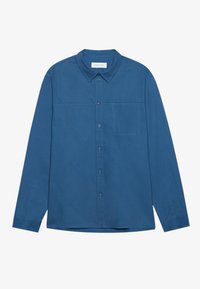 Camisa de manga larga en azul sólido, confeccionada con tela ligera. Presenta un collar abotonado, un bolsillo frontal y una textura suave.