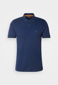 Polo bleu marine à manches courtes avec patte à deux boutons et petit détail patch sur la poitrine gauche.