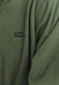 Felpa in pile verde oliva con scollo a V, dotata di un logo ricamato nero sul lato sinistro del petto e tessuto strutturato.