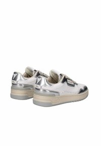 Baskets blanches avec un talon métallique argenté, une tige en cuir lisse, une semelle beige et des détails perforés. Comprend "1985" embossé sur le côté.