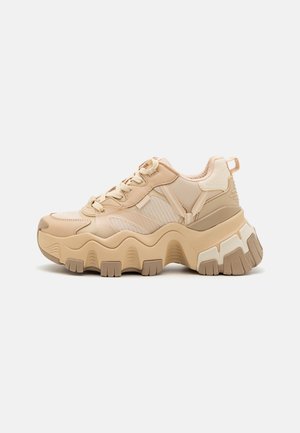 Klobige beige Sneaker mit strukturiertem Mesh und glatten synthetischen Elementen, ausgestattet mit dicken Gummisohlen mit wellenförmigem Design und gepolstertem Kragen.
