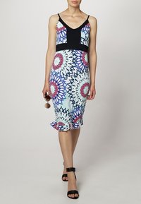 Suknja sa crnim gornjim delom, šarenim kružnim uzorcima i volanima na dnu. Tkanina je glatka, sa podesivim trakama.