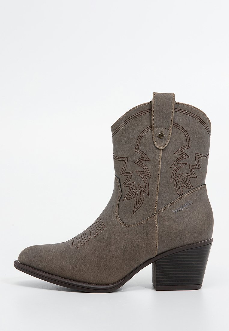 Bota de cowboy sintética marrón con punta afilada, tacón apilado de 3 pulgadas y costura decorativa de patrones de hojas en el tubo.