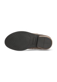 Zapato de ante marrón con una suela de goma negra texturizada, que presenta un patrón de dibujo geométrico y un acento en el talón de cuero liso.