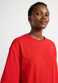 Rode katoen t-shirt met een relaxte pasvorm, korte mouwen en een ronde hals. Gladde textuur zonder zichtbare patronen of accenten.
