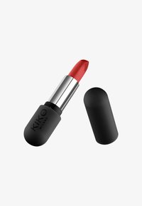 Labial rojo con una textura suave, alojado en un estuche negro mate. La tapa plateada es cilíndrica con una parte superior redondeada y logo grabado.