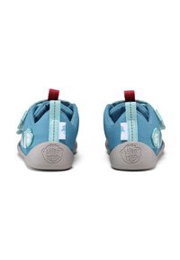 Scarpe flessibili blu con fasce in velcro, caratterizzate da una suola grigia strutturata e un distintivo giocoso sul lato, progettate per comfort e supporto.