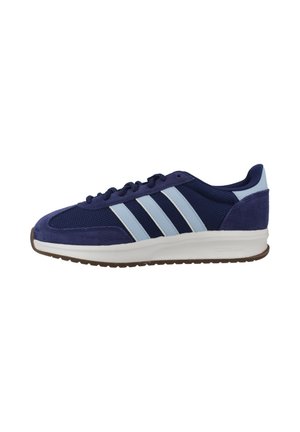 Zapatilla deportiva azul marino con rayas azul claro, suela blanca, parte superior de malla texturizada y ante, y suela exterior marrón con dibujo.