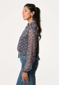 Transparante blouse met lange mouwen in marineblauw met een bloemenpatroon in rozenrood en roze. Losse pasvorm met een knoopkraag en elastische manchetten.