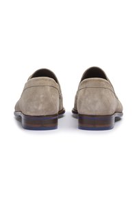 Mocassins en suede beige clair, avec un bout arrondi, un petit talon et des rayures brunes et bleues, ainsi que des détails de couture subtils à l'arrière.