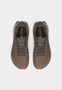 Ζεύγος πεζοπορικών παπουτσιών σε ελιά πράσινο με κόκκινες λεπτομέρειες, σχέδιο με κορδόνια και αεριζόμενο πάνω μέρος, απεικονιζόμενα από πάνω σε λευκό φόντο.