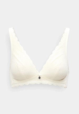 Hvid blondes-bh med bølgede kanter, tekstureret stof og en lille dekorativ charm foran i midten.