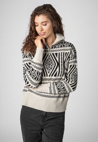 Strickpullover mit hohem Kragen, mit einem geometrischen Muster in Schwarz und Creme, gerippten Bündchen und Saum für zusätzliche Textur.