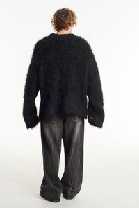 Black, fluffy sweater with a loose fit, dropped shoulders, and long sleeves; paired with loose-fitting gray jeans.