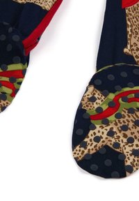 Calze stampate con una base blu scuro, motivo leopardato, accenti rossi e verdi e punti antiscivolo testurizzati sulle suole.
