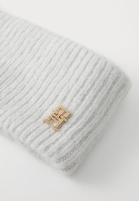 Hall kuue ribaga, mille esiosas on selgelt välja toodud kuldse tooni logo aktsent. Pehme tekstuur ja hubane välimus.