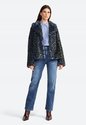 Faux fur leopard print jacket in black and blue, featuring a wide collar and button closure. Paired with a striped shirt and denim jeans.