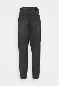 Jeans de mezclilla negra con cintura alta, piernas ajustadas y dos bolsillos traseros; cuentan con una textura suave y un parche de tela negra en la cintura.