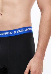 Μαύρα boxer briefs με μπλε ελαστική μέση που αναγράφει «KARL LAGERFELD» με λευκά γράμματα και λογότυπο. Ομαλή υφή υφάσματος.