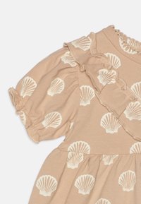 Helles beiges Kleid mit weißem Muschel-Muster, Rüschensäumen und einem gerafften Rock. Weicher Stoff mit einem strukturierten Ausschnittsdetail.