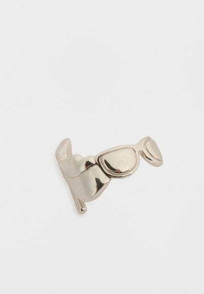 Δαχτυλίδι ασημί σχεδιασμένο ως ζευγάρι γυαλιά ηλίου με ανακλαστικούς, καμπυλωτούς φακούς σε λευκό φόντο.