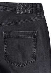 Jeans de mezclilla negra con una etiqueta texturizada negra en la cintura, que cuentan con un bolsillo trasero con costuras reforzadas y un acabado elegante y suave.