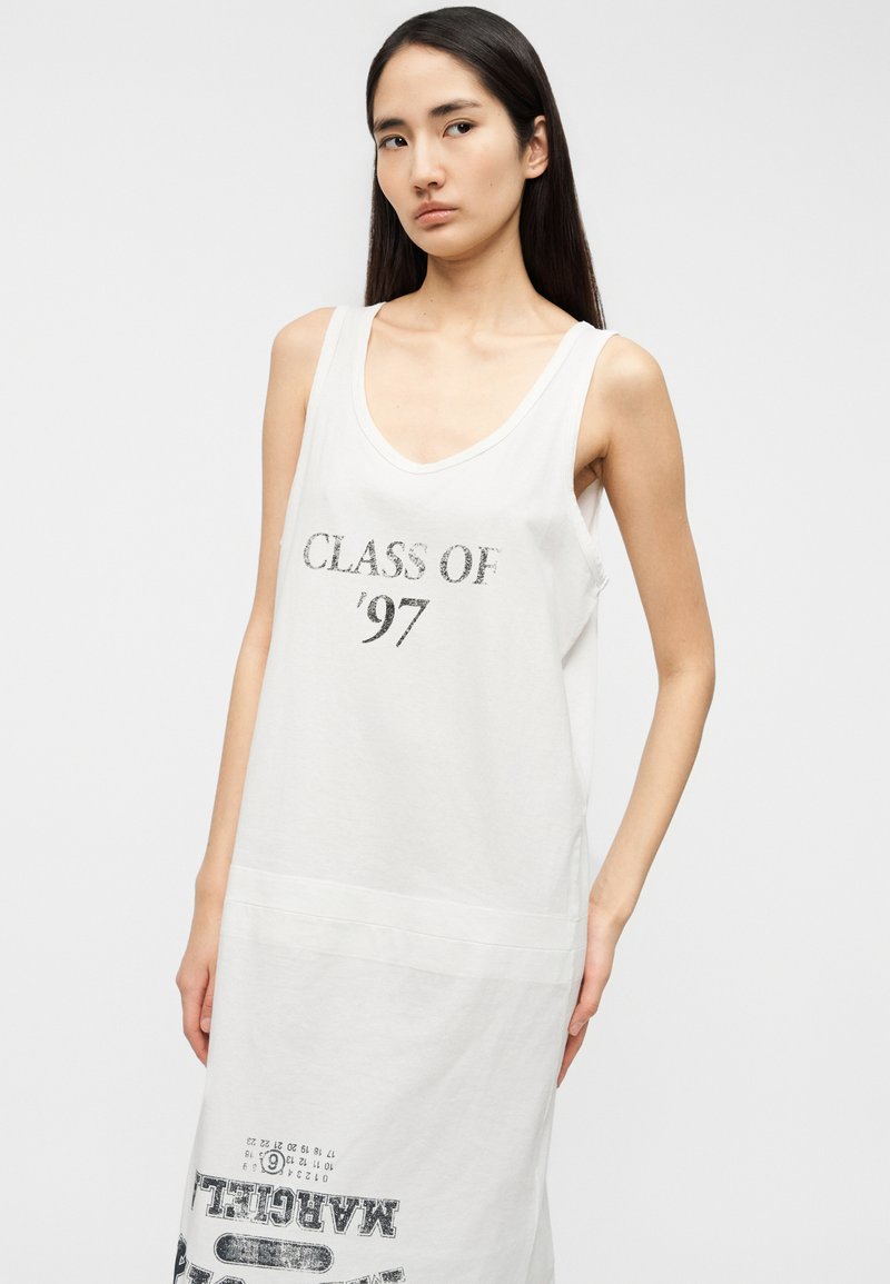Robe blanche sans manches en coton, avec une grande inscription "CLASS OF '97" en noir et un texte supplémentaire en gras à l'ourlet.