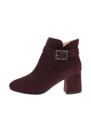 Dark burgundy suede ankle boot with block heel and decorative textured metal buckle strap around the upper ankle.