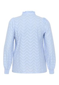Blouse bleu clair à manches longues, avec un motif en zigzag et un col froncé. Texture douce, poignets élastiqués aux extrémités des manches.
