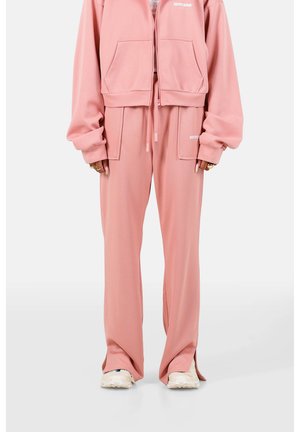 Lys rosa, cropped zip hoodie med to forlommer. Sammen med matchende vide bukser med snøre i taljen og blød tekstur.