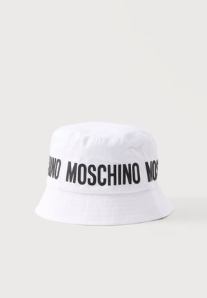 Biely klobúk typu bucket s čiernym textom "MOSCHINO" opakovane vytlačeným okolo koruny, zobrazený na jednoduchom svetlom pozadí.