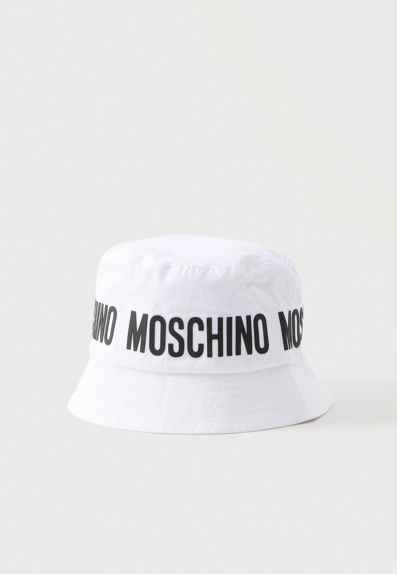 Λευκό καπέλο τύπου bucket με μαύρο κείμενο "MOSCHINO" που επαναλαμβάνεται γύρω από την κορυφή, απεικονίζεται σε απλό ανοιχτό φόντο.