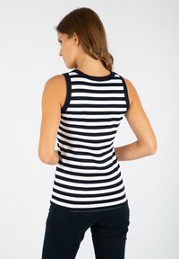 Bez rękawów czarno-biała tank top w paski z zaokrąglonym dekoltem i czarnymi wykończeniami. Miękka tkanina i dopasowany krój.