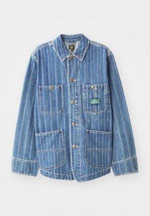 Heled sinine teksajakk, millel on vertikaalsed valged triibud, sisaldab nelja taskut, kraed ja kuldsetes toonides nööpe. Brändi silt on nähtav vasakul taskul.