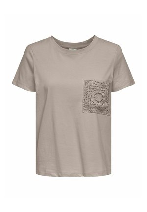 Beżowa bawełniana koszulka z okrągłym dekoltem, z kieszonką w kształcie kwadratu z koronką po lewej stronie klatki piersiowej. Krótkie rękawy dopełniają całość.