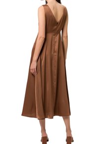 Robe marron en satin coupe trapèze, dos en V, sans manches, longueur au-dessous du genou, dotée d'une fermeture éclair dissimulée et d'une texture lisse.