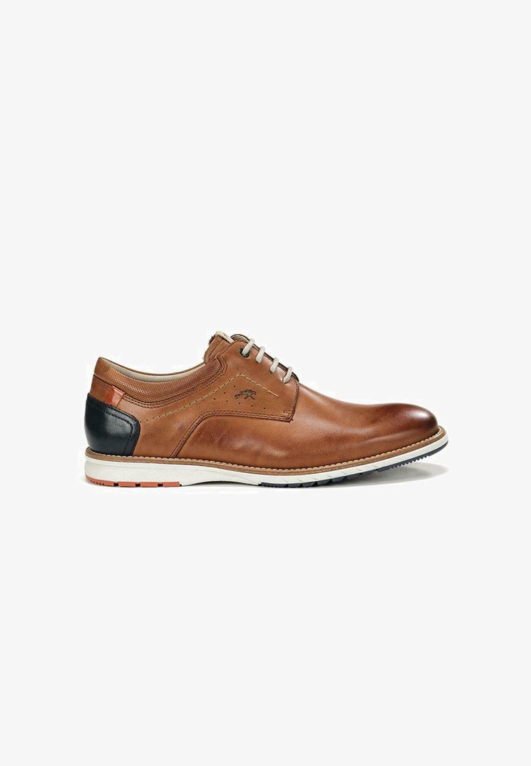 Zapato de cuero marrón con acabado suave, cuenta con un acento en el talón en color marino, suela blanca y costuras ligeras. Diseño con cordones y detalles mínimos.