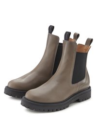 Bruine leren Chelsea boots met elastische zijpanelen, textuur zwarte rubberen zool en aantreklussen. Gladde afwerking met een ronde neusvorm.