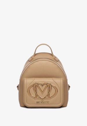 Sac à dos en cuir beige, de forme arrondie, avec un rabat avant embossé d'un logo "M" entrelacé et une fermeture éclair en haut.