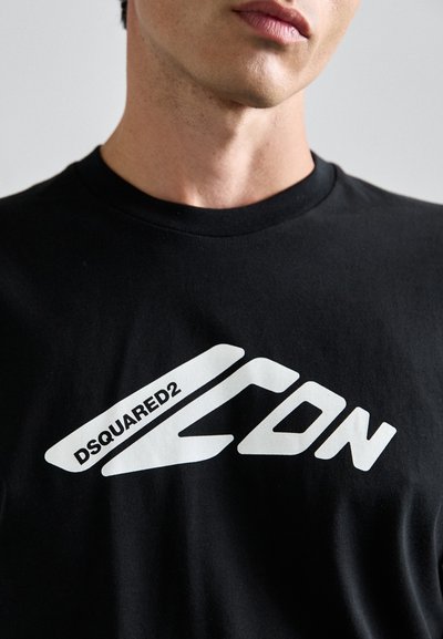 Must valge t-särk, mis on valmistatud puuvillast, esitleb julget valget logo, millel on stiilne ja nurkne disain tekstide "DSQUARED2" ja "ICON".